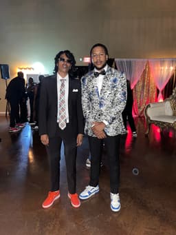 kidd and her cousin, riq, pose in suit, ties, and sneakers at Rico's 50th birthday ball